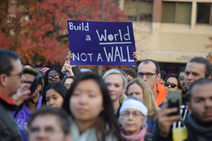 A protester holds a sign that says "build a world not a wall." The sign is in reference to president-elect Donald Trump's campaign promise to build a wall between the U.S. and Mexico.