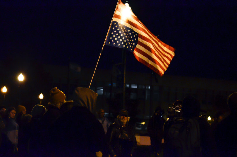 Demonstrators hold the American flag upside down in protest of Donald Trump. 