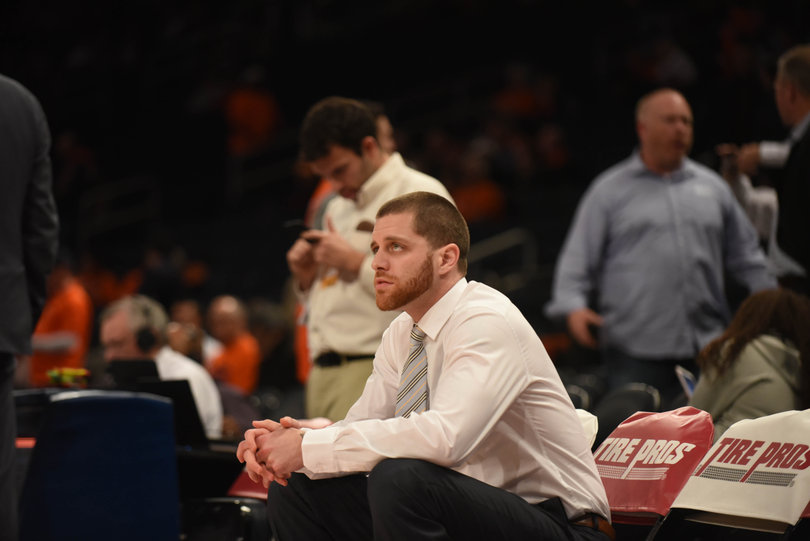 Former Syracuse player and current team staff member Eric Devendorf sits on the bench.