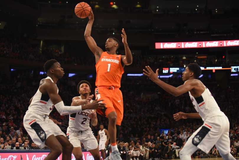 Howard jumps to get the ball past three Huskies defenders.