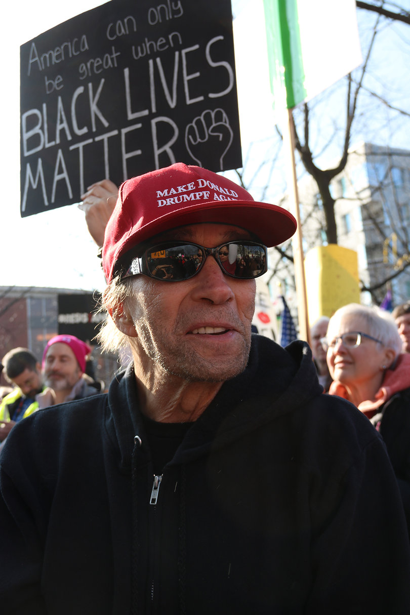 A man wears a "Make Donald Drumpf Again" hat.