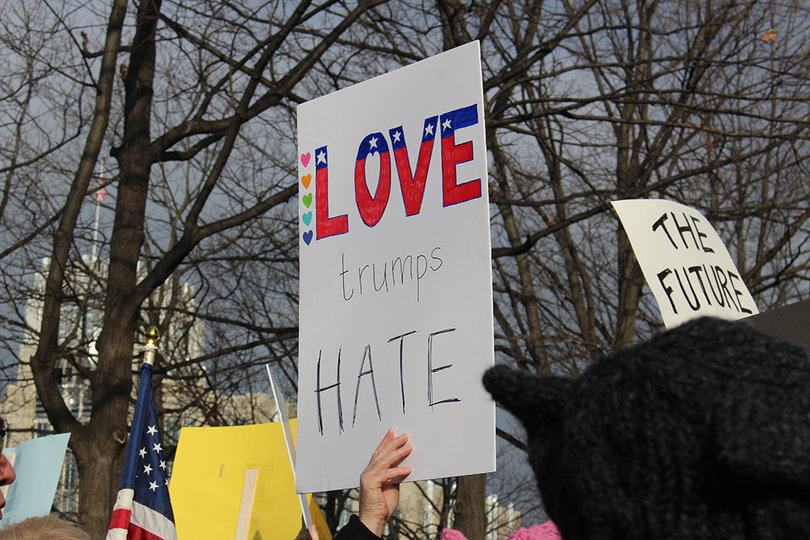 A sign reads "love trumps hate," a popular chant and slogan among anti-Trump activists.