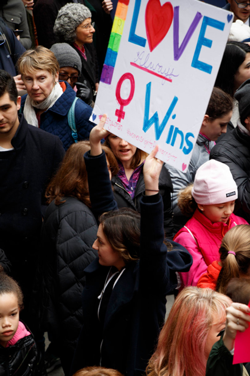A woman holds a sign that reads "Love wins."