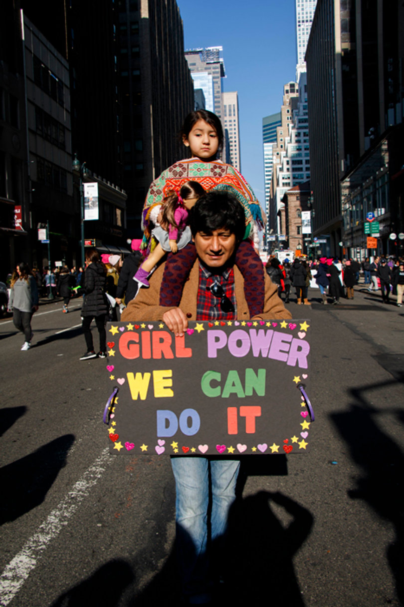 A parent and child walk the streets of New York City.