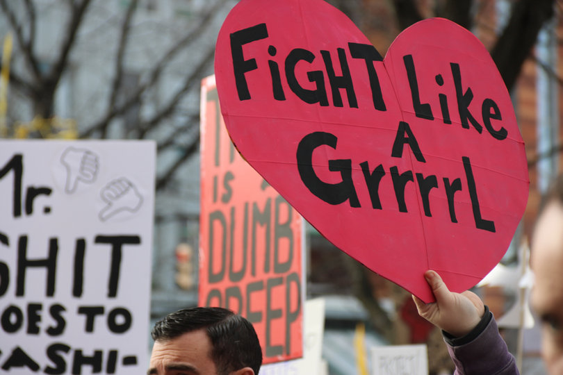 A sign in the Syracuse march reads "Fight like a grrrrl."
