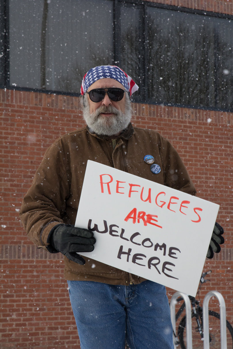 A protester holds a sign that reads, "Refugees are welcome here."