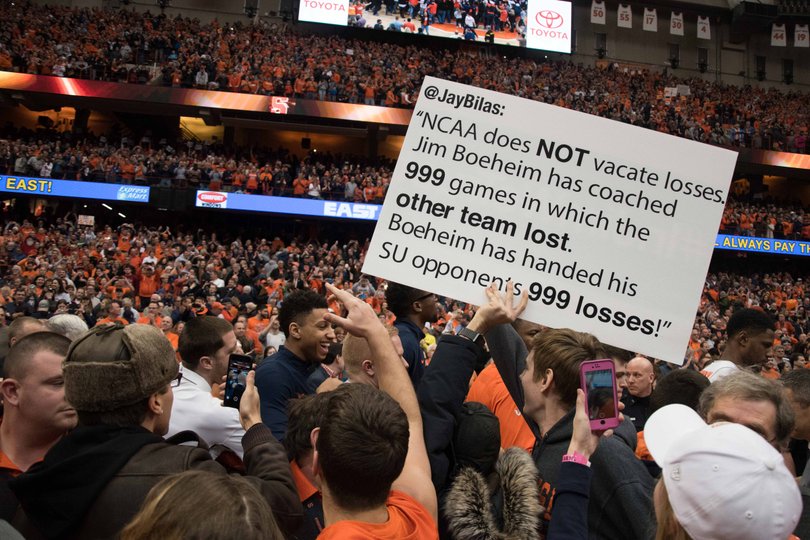 A fan holds up a sign that had a tweet from ESPN analyst Jay Bilas on it.