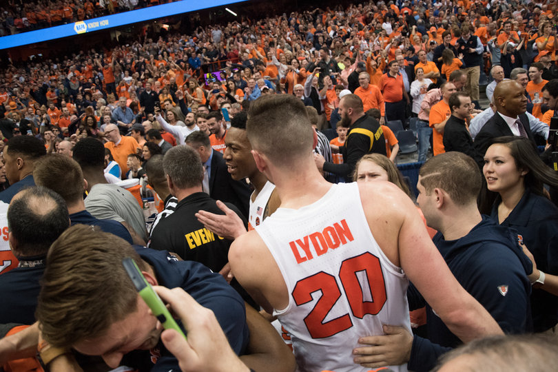 Lydon exits the court with the help of a security guard as crowds sward him. 