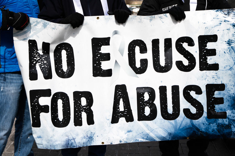 Marchers hold a sign "No Excuse for Abuse," calling for an end to domestic and sexual violence. 