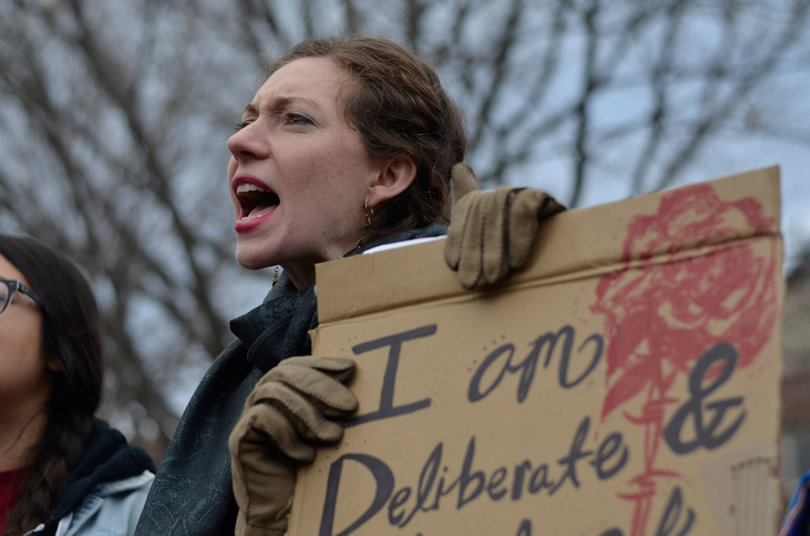 Terese Gagnon shows her agreement with the speaker and also holds a sign showing her support for the rally's efforts.