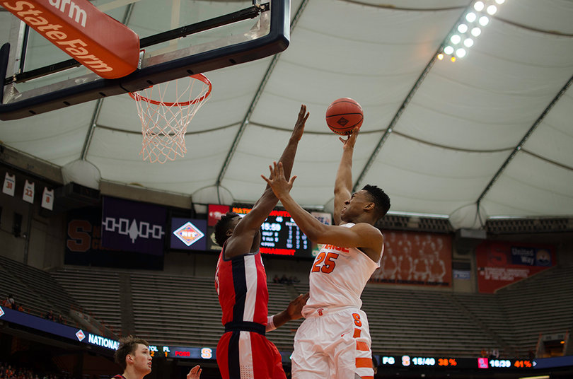 Battle goes toward the basket with a defender in his way.
