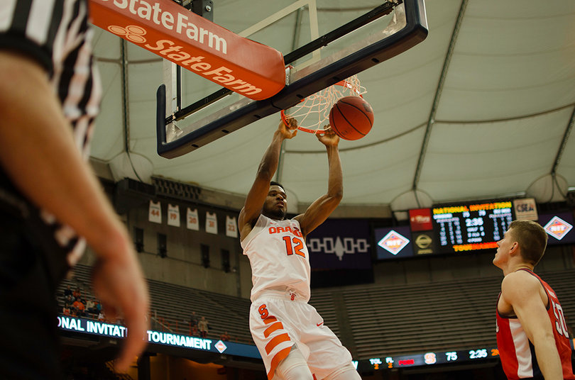 Thompson slams home a dunk as an Ole Miss player watches the ball fall through the net.