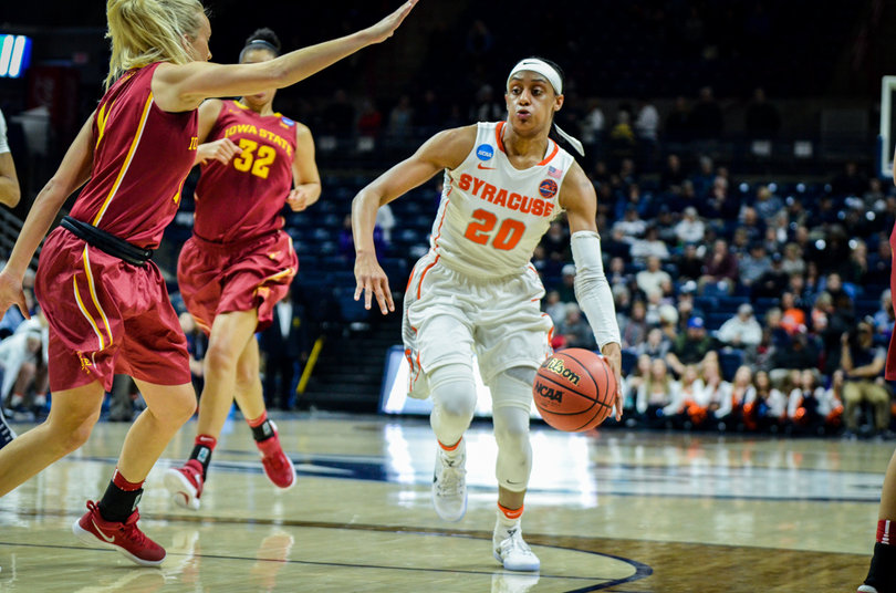 Sykes dribbles near the free-throw line with a defender in her way.