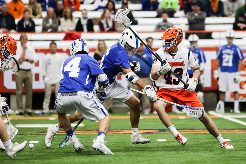 Both Duke and Syracuse players ran past the ground ball. 