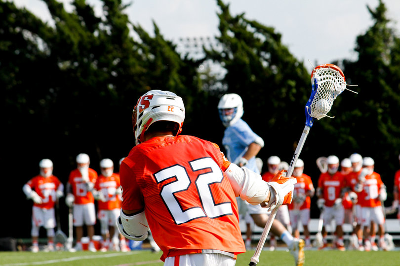 Evans runs with his stick held high in one hand. 