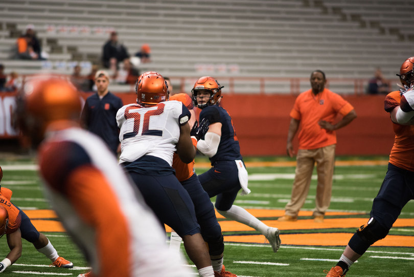 Starting quarterback Eric Dungey drops back to pass as head coach Dino Babers looks on. 