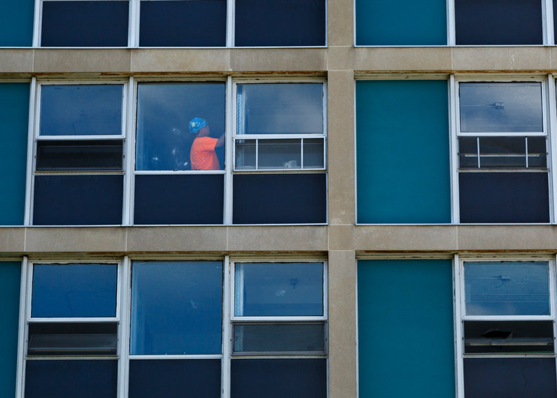 A construction worker in DellPlain Hall is seen through a window, as dorm room upgrades continue before the fall semester begins. Photo taken July 18, 2017