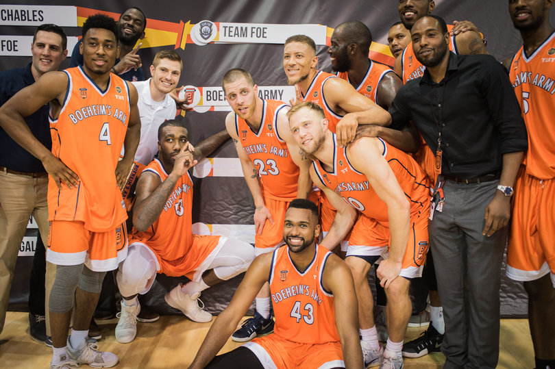 The squad celebrates the four-point win with a photo shoot in front of the bracket.