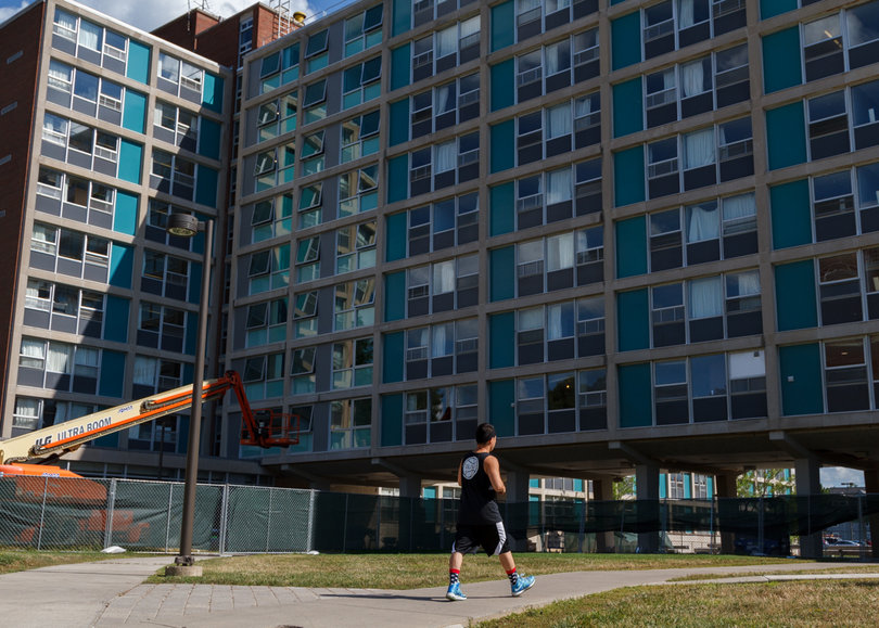 A student passes by DellPlain Hall, where upgrades to the building's dorms will be completed before the fall semester starts. Photo taken Aug. 8, 2017