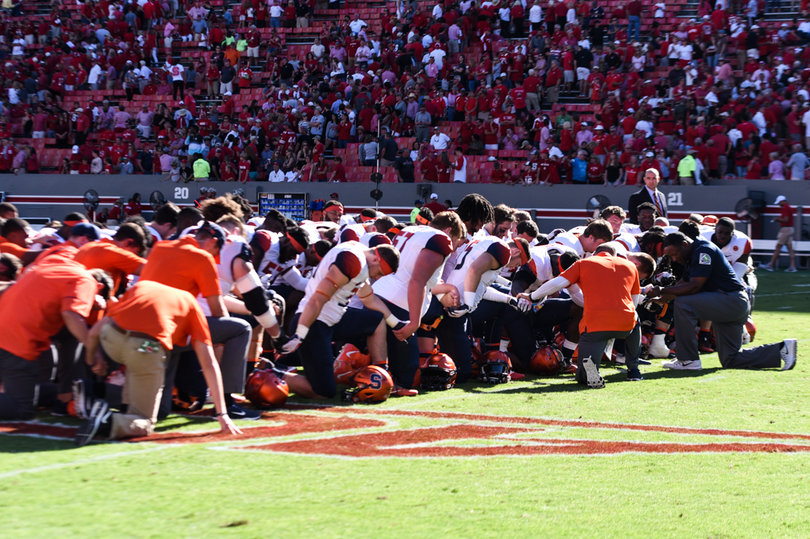 The Orange all took a knee on the field after
 the game. 