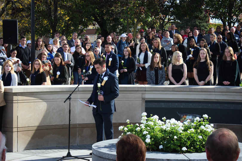 Dozens of people surrounded the Remembrance Scholars on Friday, watching the Rose Laying Ceremony. 