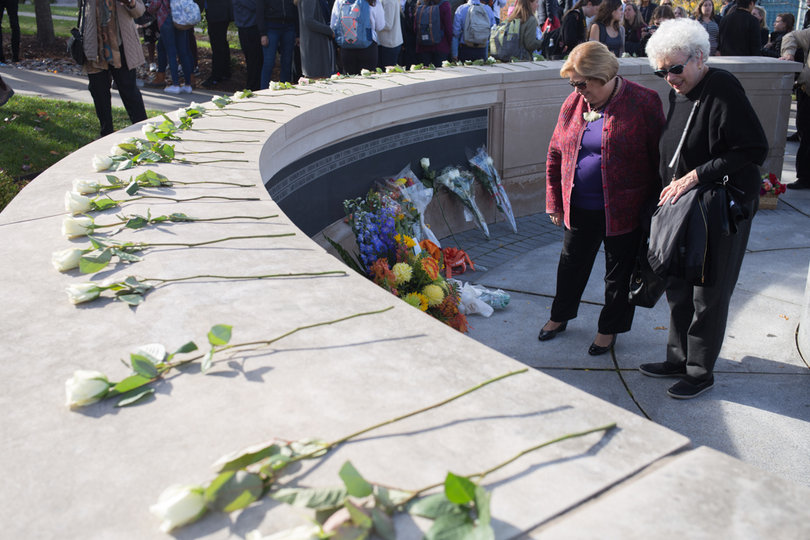 After Remembrance Scholars placed roses on the wall, SU Chancellor Kent Syverud and others put flowers along the wall. 
