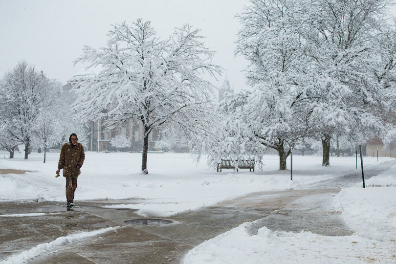Miguel Balbuena, a Syracuse University alumnus of 1993 who majored in economics and public administration, walks across the Quad on Friday after Syracuse University canceled classes due to a major snowstorm.