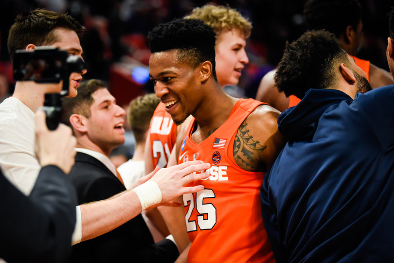 Battle pushes through a crowd of happy Syracuse players after the win.