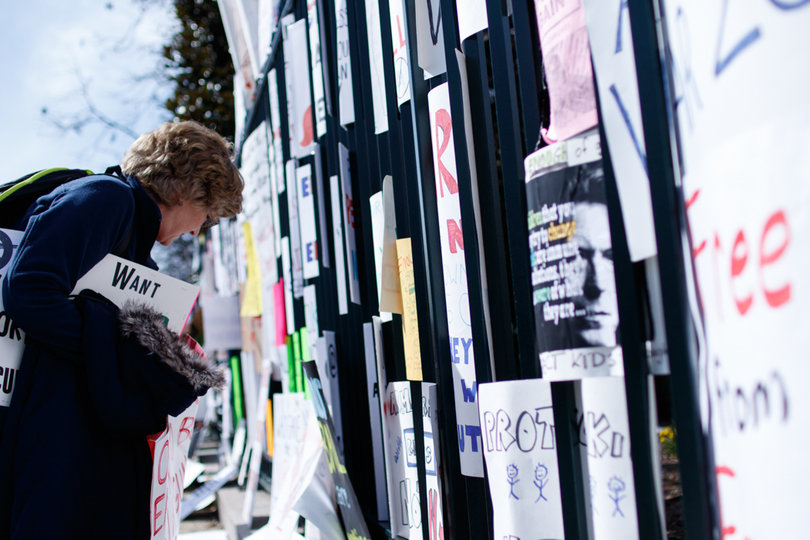 Dozens of signs from the rally were placed on a fence.