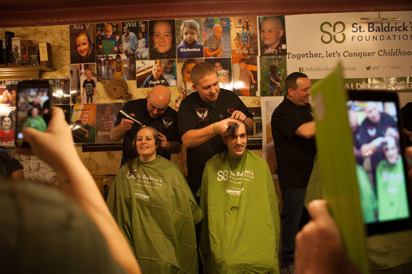 Scott Gleason, right, and Christine Gonzalez get their heads shaved for the fifth and first time respectively.