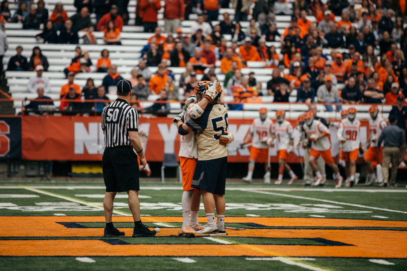 Brothers Danny (white) and Joe (gold) hug at midfield following the games conclusion. 