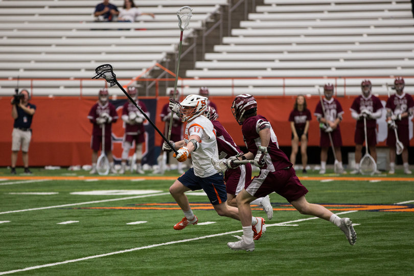 The defender Kennedy runs past Colgate players.