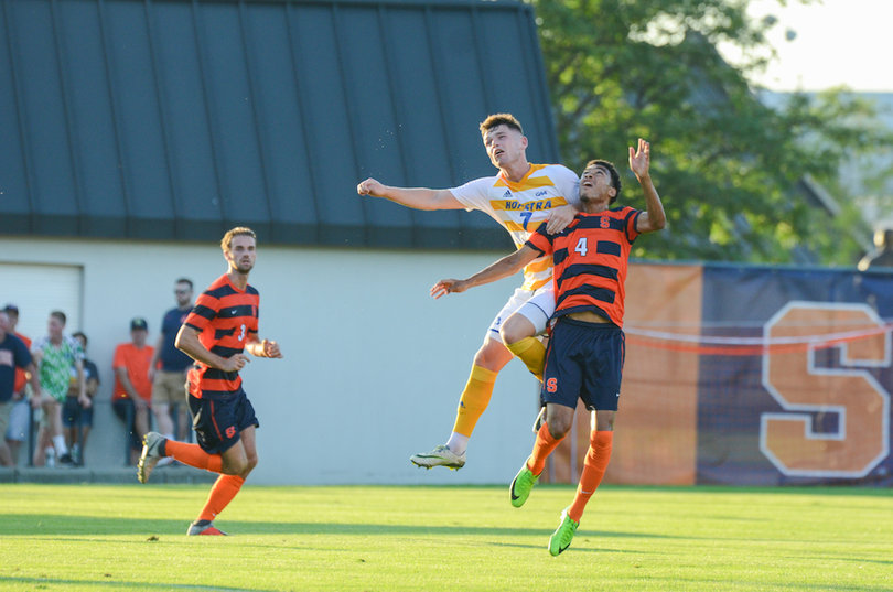 A Hofstra defender fights Djimon Johnson for a ball.