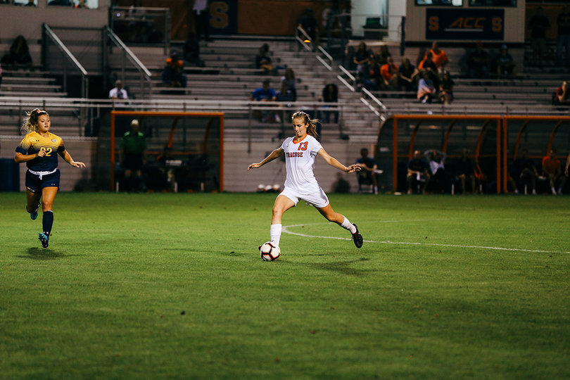 Defender Shannon Aviza strikes a ball out of the SU end. 