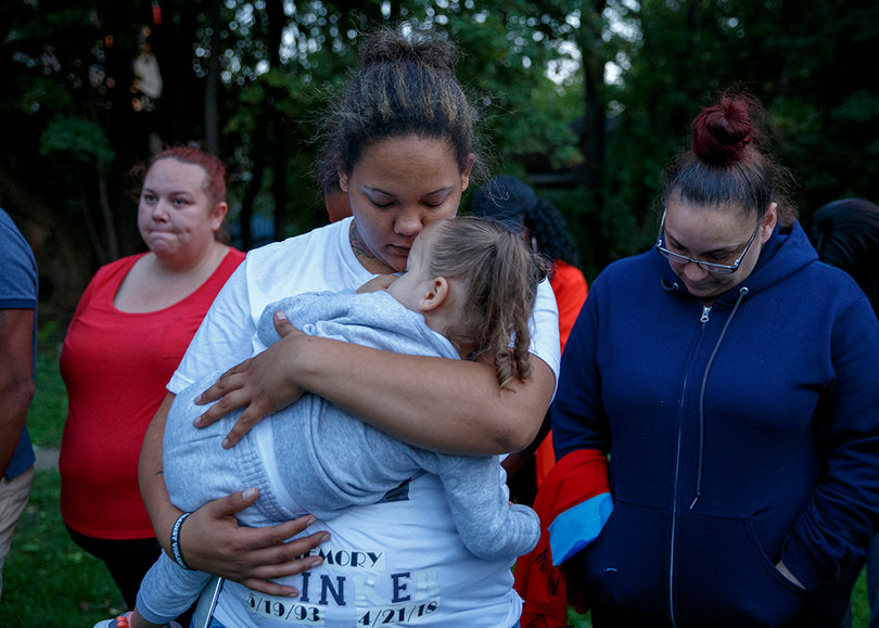 Members of Lawrence Moore Jr.'s surviving family participate in a moment of prayer.