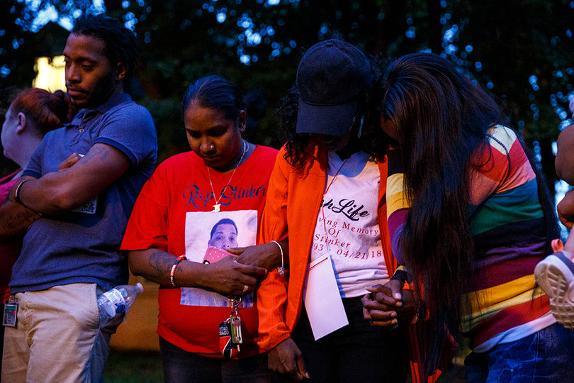 Members of Lawrence Moore Jr.'s surviving family embrace each other during an emotional vigil.
