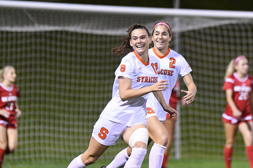 Jenna Tivnan and Kate Donovan smile as they run down the field.