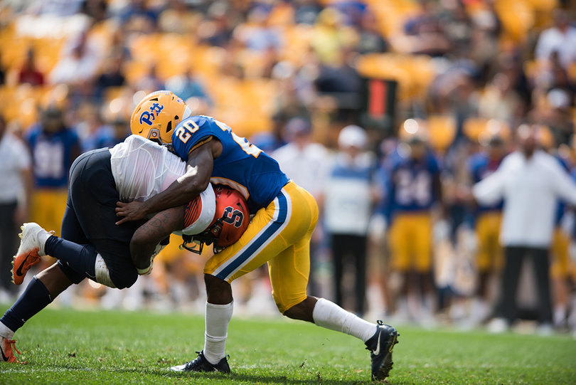 Syracuse running back Dontae Strickland (4) is tackled by Pittsburgh defensive back Dennis Briggs (20).