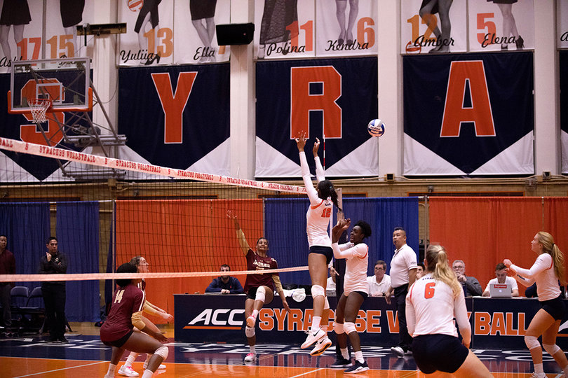 Boston College hits the ball between Syracuse blockers' outstretched hands. 