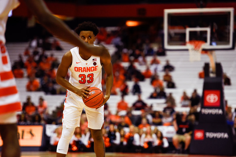 A transfer from East Carolina, Hughes looks to pass from the top of the key.
