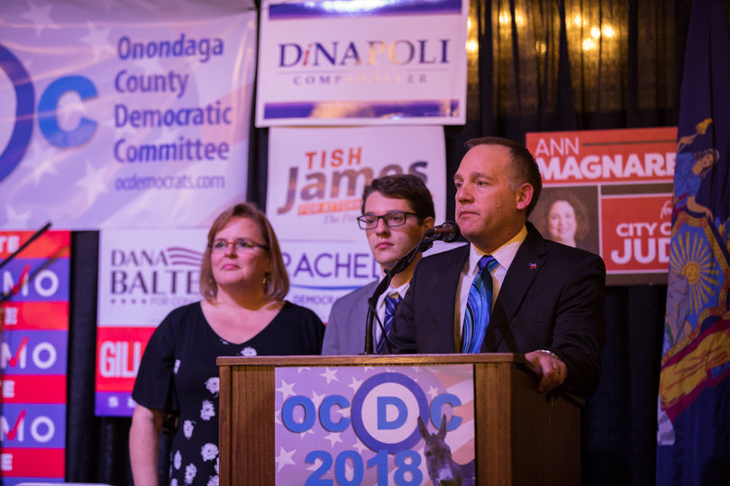 Mike Montes concedes defeat to incumbent Onondaga County Sheriff Gene Conway while joined on stage with his family.