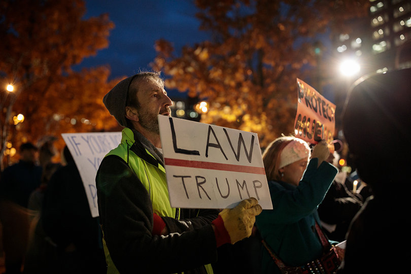 Jim McKeever, a retired journalist, follows the chants of fellow protesters at the event.