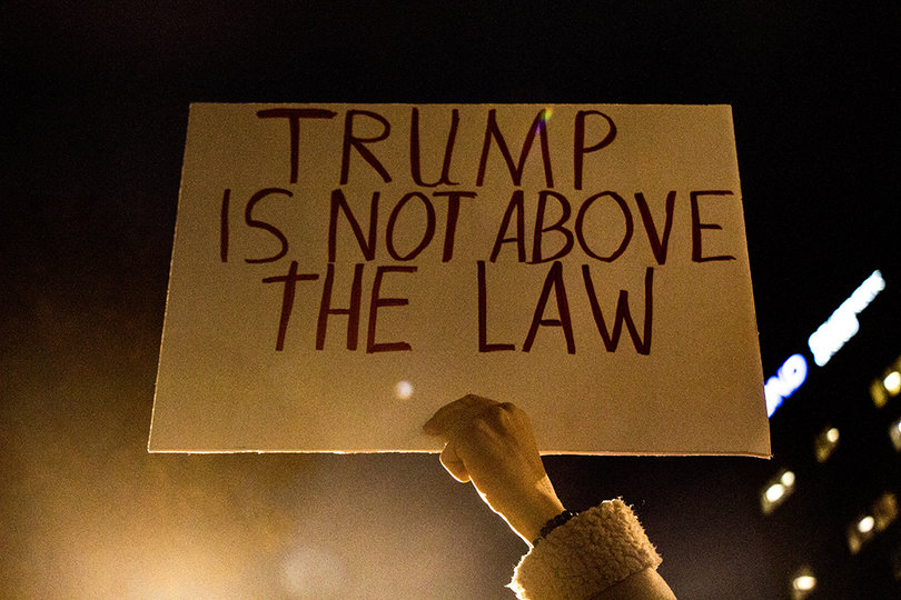 A protester holds up a sign at the "Nobody is Above the Law" rally.