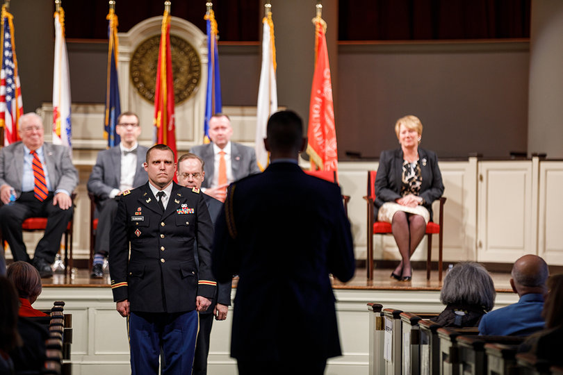 Members of the ROTC program present a flag to Chancellor Kent Syverud, which was raised outside of the chapel after the ceremony.