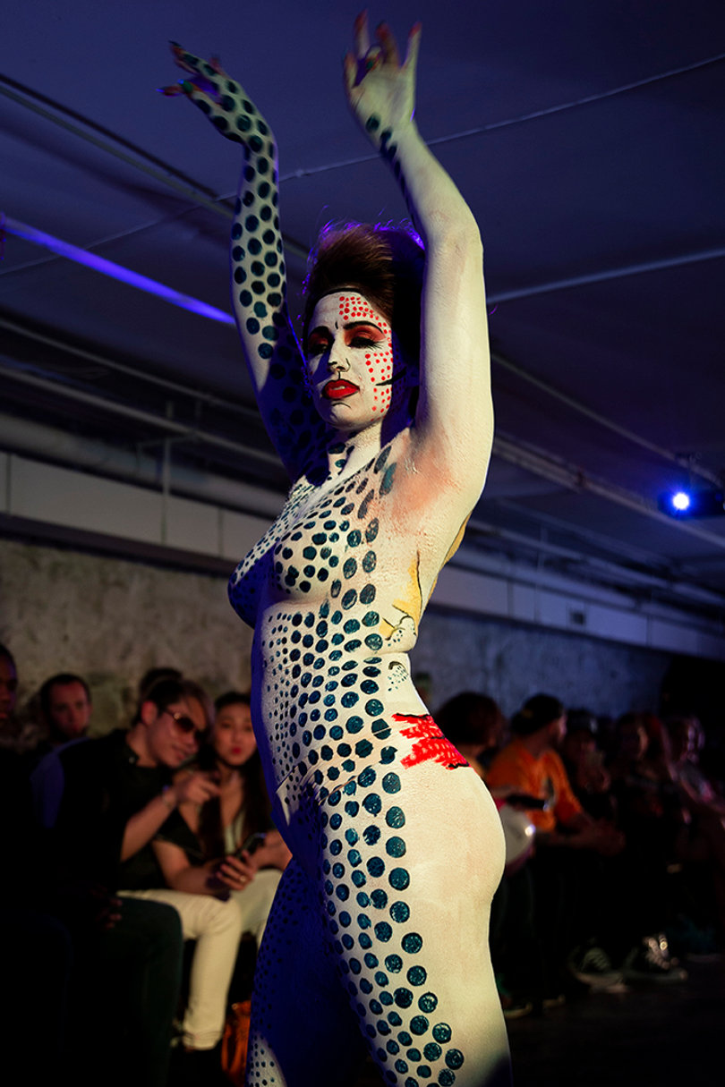 A model stops to pose at the end of the runway in her 1960s inspired body paint.