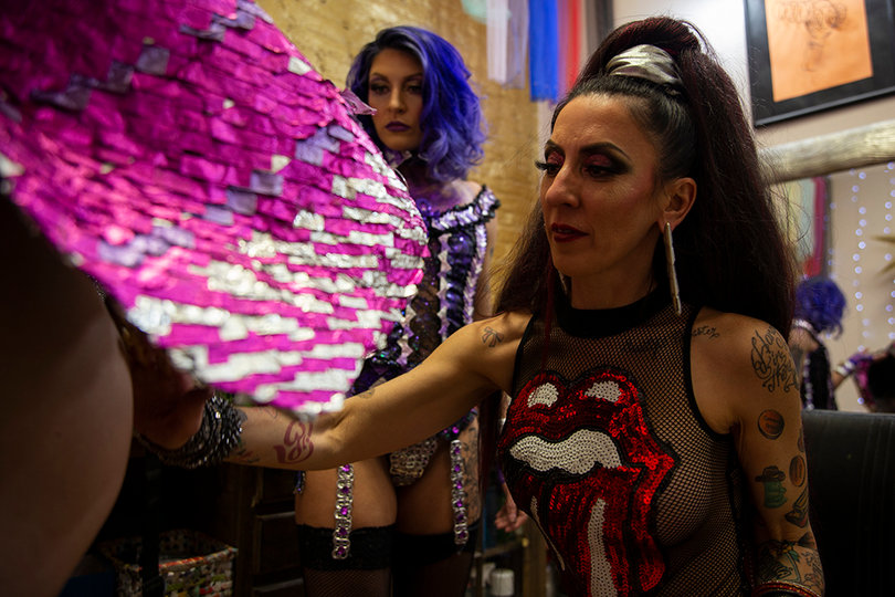 A S&M Designes reprenative applies glitter to a model dressed in a David Bowie-inspired costume for the 1980s theme part of the show. 