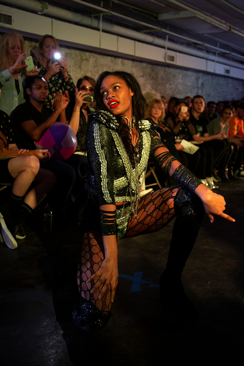 A model kneels to emphasize the 1980s outfit.