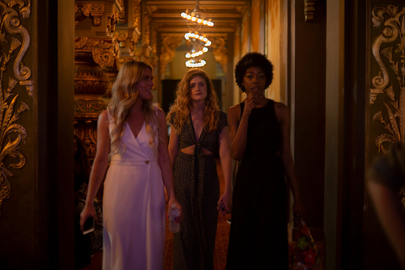 Three models leave the backstage area after finishing for the night.