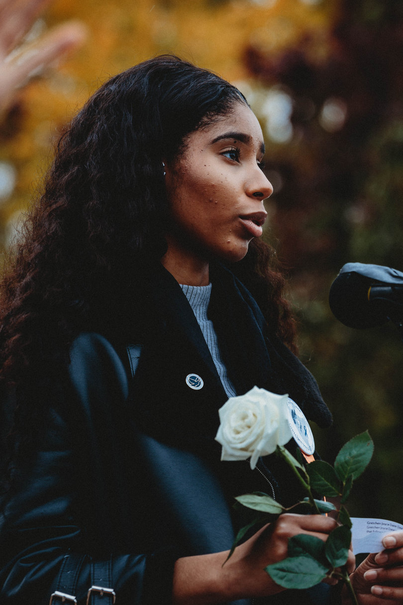 Scholar Izmailia Sougoufara reads her passage in honor of Gretchen Dater before placing her rose.