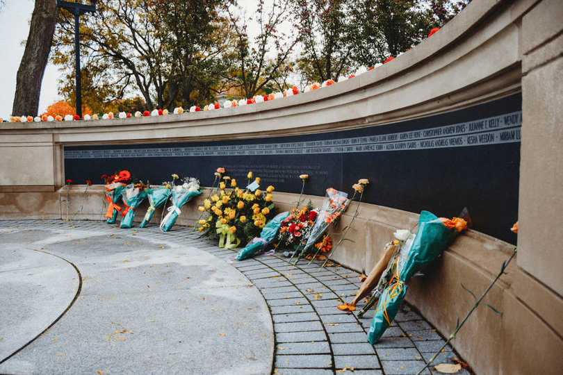 The flowers of the public lay against the Remembrance Wall.